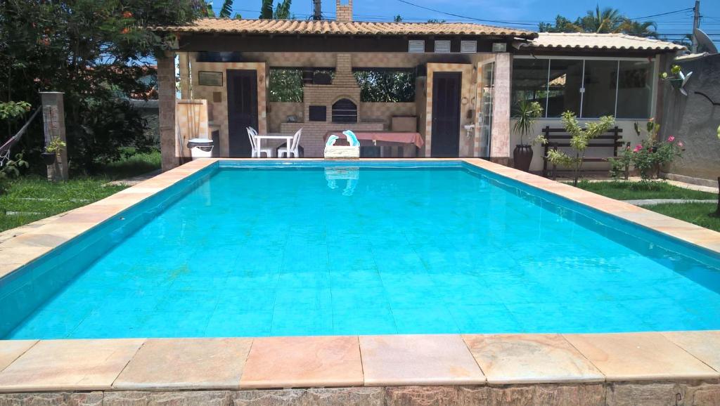 阿拉魯阿馬的住宿－Recanto Suítes，一座房子后院的游泳池