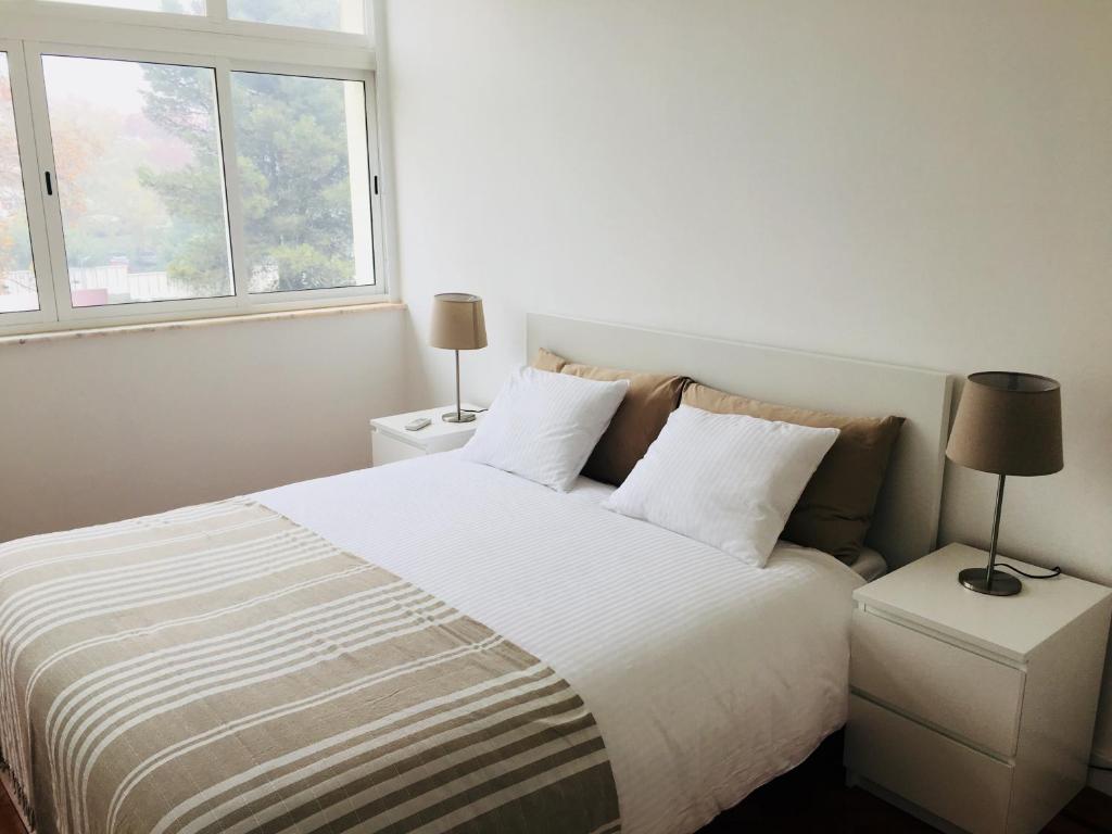 um quarto com uma cama grande e 2 janelas em Apartment near the airport em Lisboa