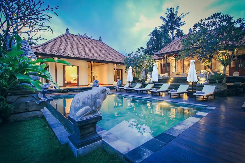 une piscine avec une statue d'oiseau au au milieu d'une maison dans l'établissement Villa Heron Ubud, à Ubud