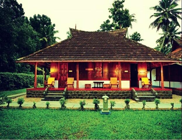 a house with a roof with chairs in a yard at Palmdale Heritage in Champakulam