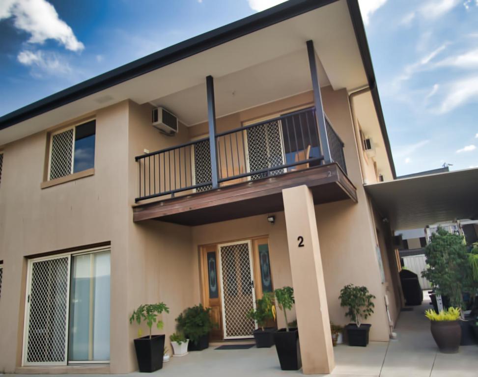 a house with a balcony and potted plants at Mount Gravatt Guesthouse in Brisbane