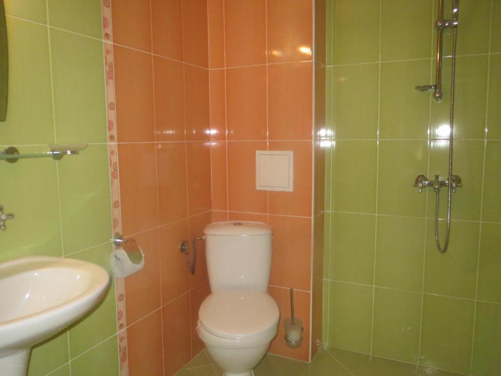 a bathroom with a toilet and a sink and a shower at Family Hotel Golden Lion in Primorsko