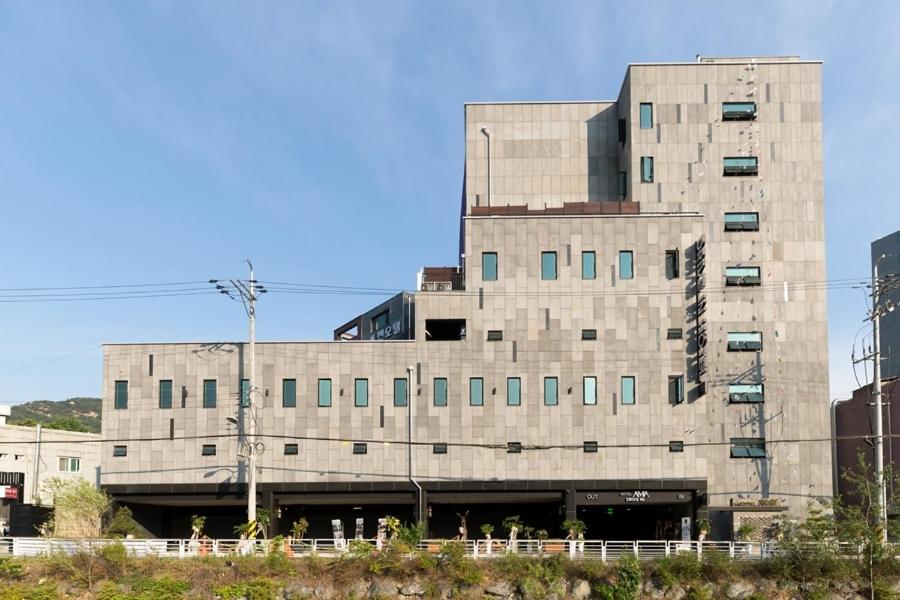 a large concrete building with windows in a city at Anyang Boutique Hotel AMA in Anyang