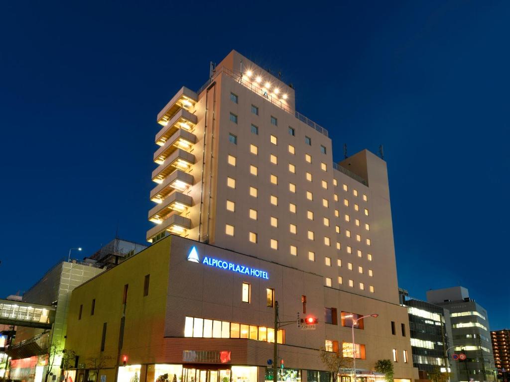 Alpico Plaza Hotel في ماتسوموتو: مبنى كبير مع علامة aania فوقه