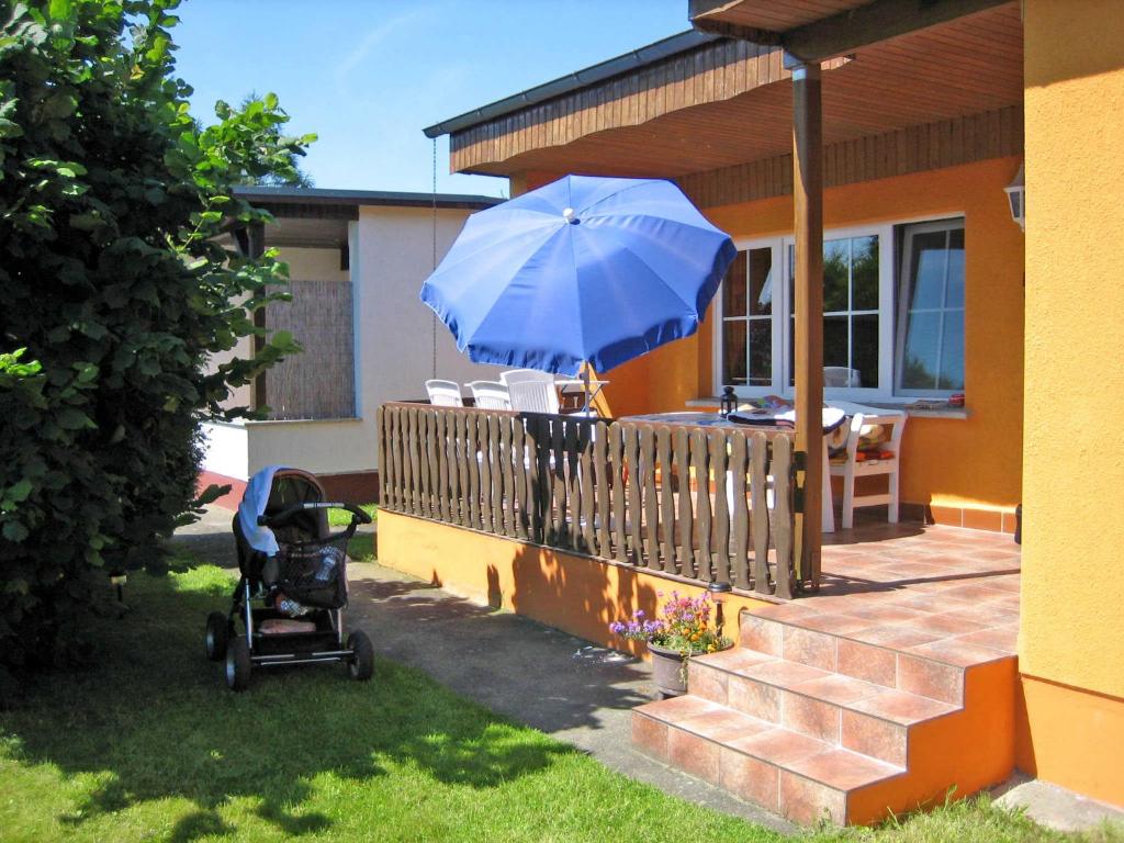 MönkebudeにあるFerienhaus Moenkebude VORP 2041の家の横の青傘を持つベビーカー