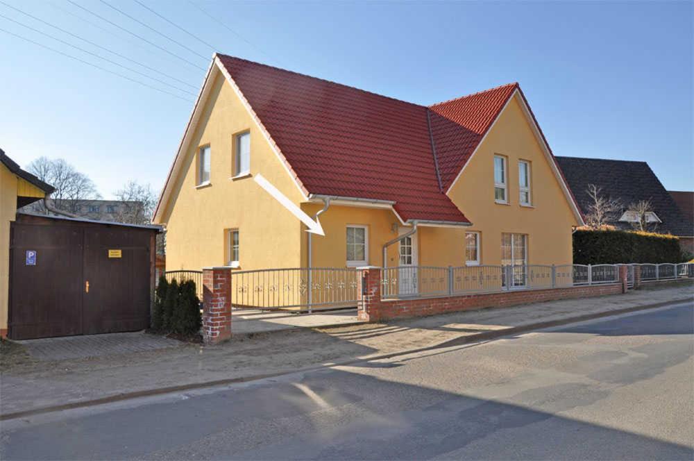 ヴァーレンにあるFerienhaus Waren SEE 8561の通路赤屋根の黄色い家