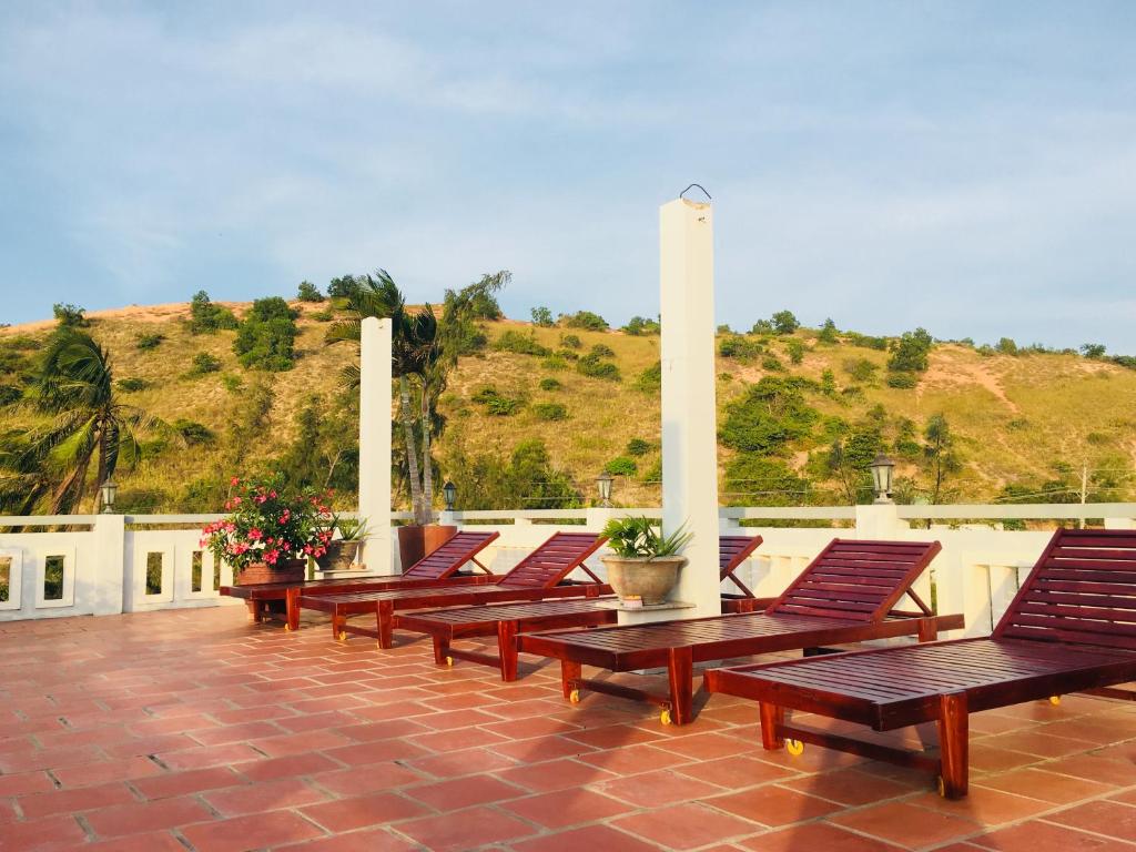 una fila di panche di legno sedute su un patio di Minh Ngoc Hotel a Mui Ne