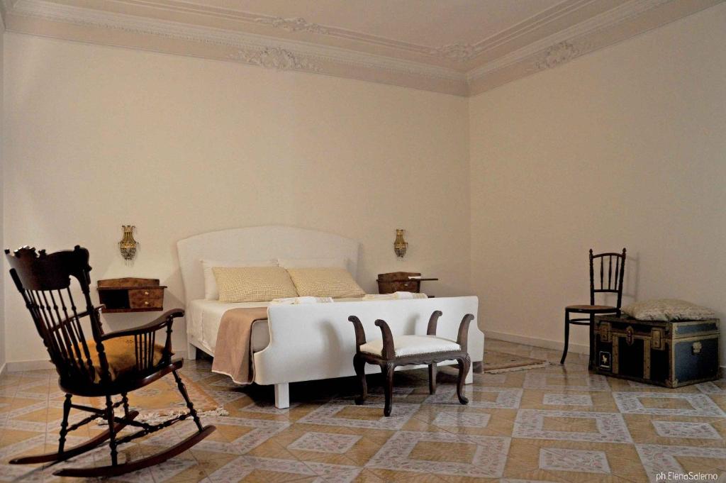 een slaapkamer met een wit bed en 2 stoelen bij Agorà b&b in Trani