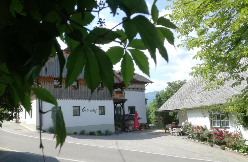 a white building with a wooden roof at Ortnerhof Ennstal in Aigen im Ennstal