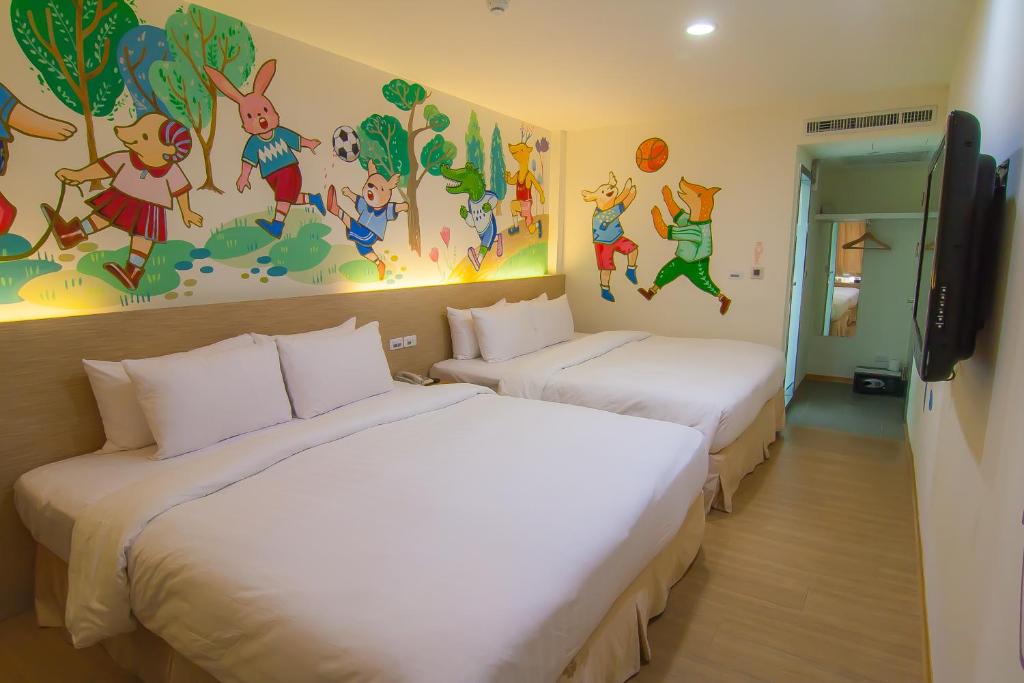 two beds in a room with a mural on the wall at Legend Hotel Kaohsiung Liuhe in Kaohsiung