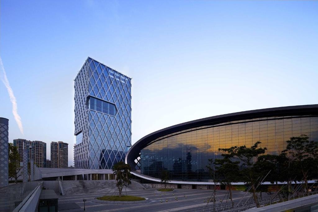 a large building in front of a city at Hotel Kapok Shenzhen Bay in Shenzhen