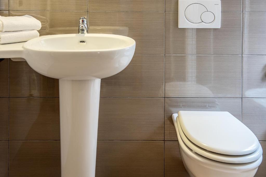 a bathroom with a white sink and a toilet at Hotel Calypso in Ventimiglia