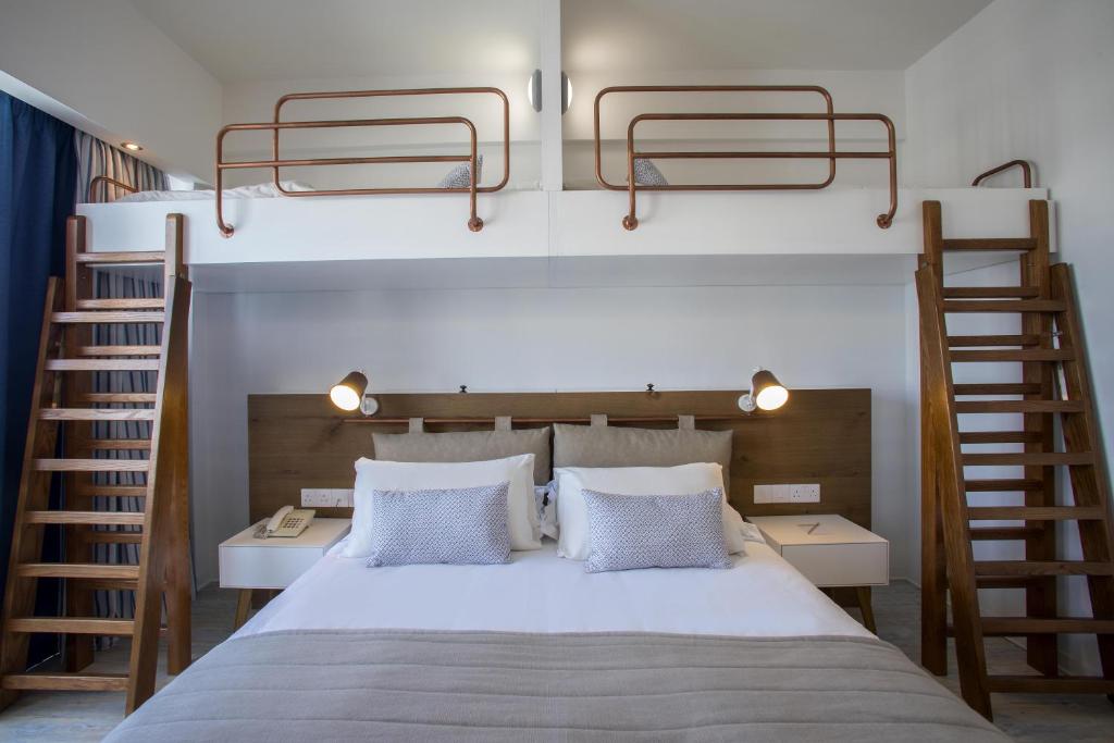 a bedroom with a bed with two bunk beds at Lordos Beach Hotel & Spa in Larnaca