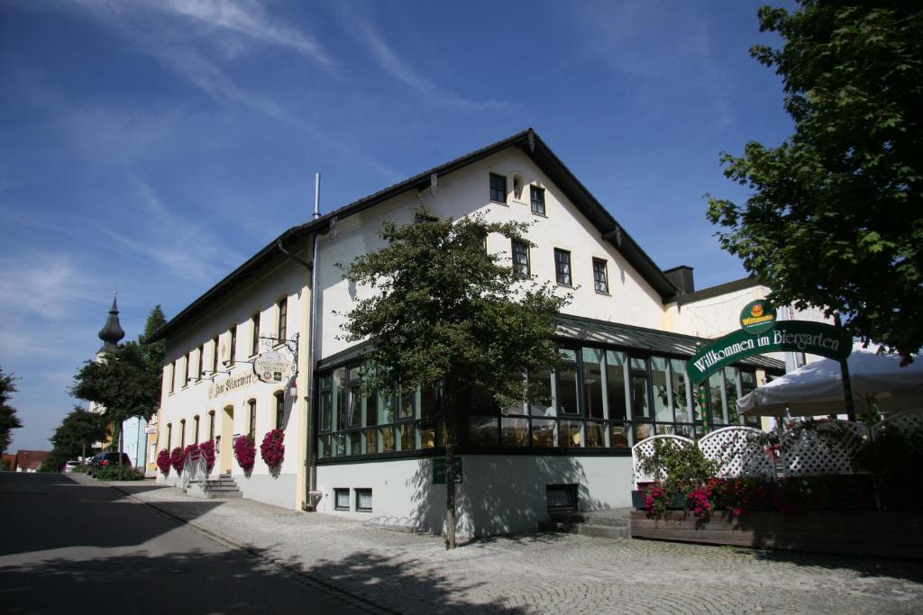 Hotel - Landgasthof Obermaier Zum Vilserwirt في Altfraunhofen: مبنى ابيض امامه شجرة