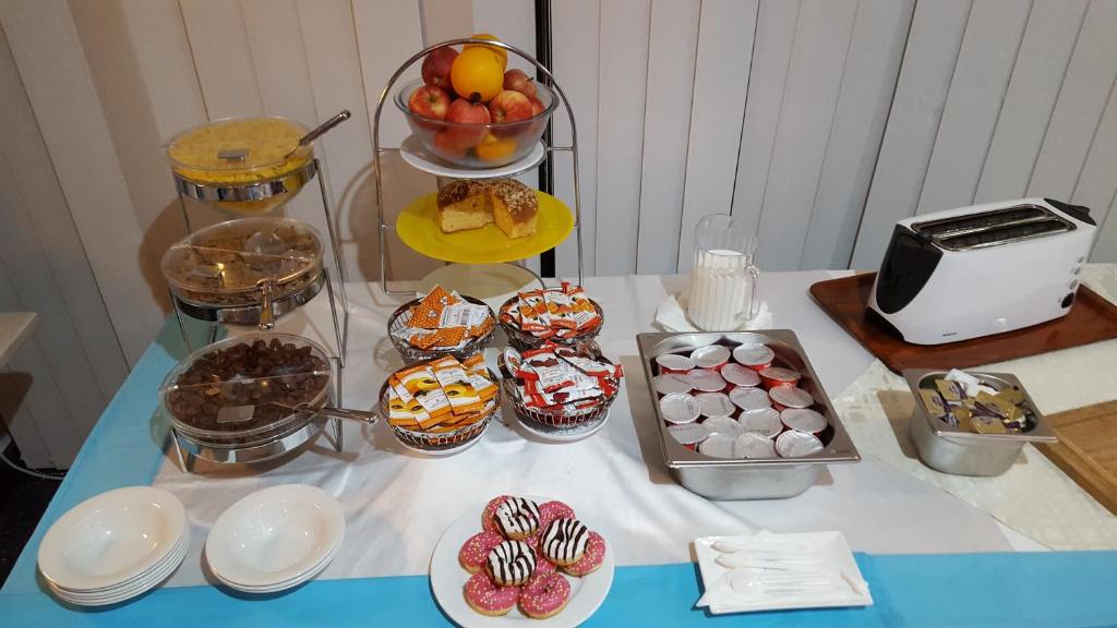 a table with a bunch of cupcakes and other desserts at Water's Edge Hotel in Birżebbuġa