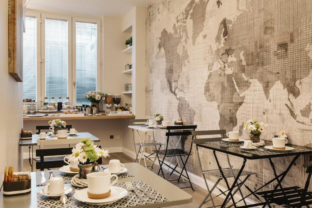 un ristorante con tavoli e una mappa del mondo sul muro di Livingstone B&B a Matera
