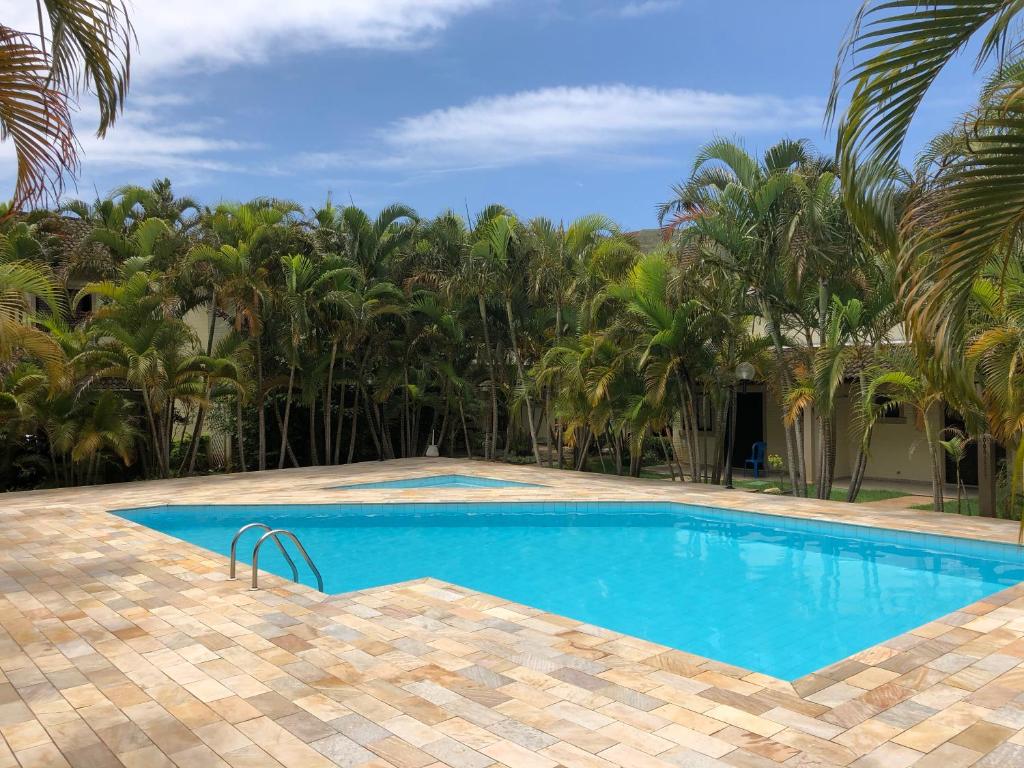 una piscina en un complejo con palmeras en Paúba Beach House, en São Sebastião