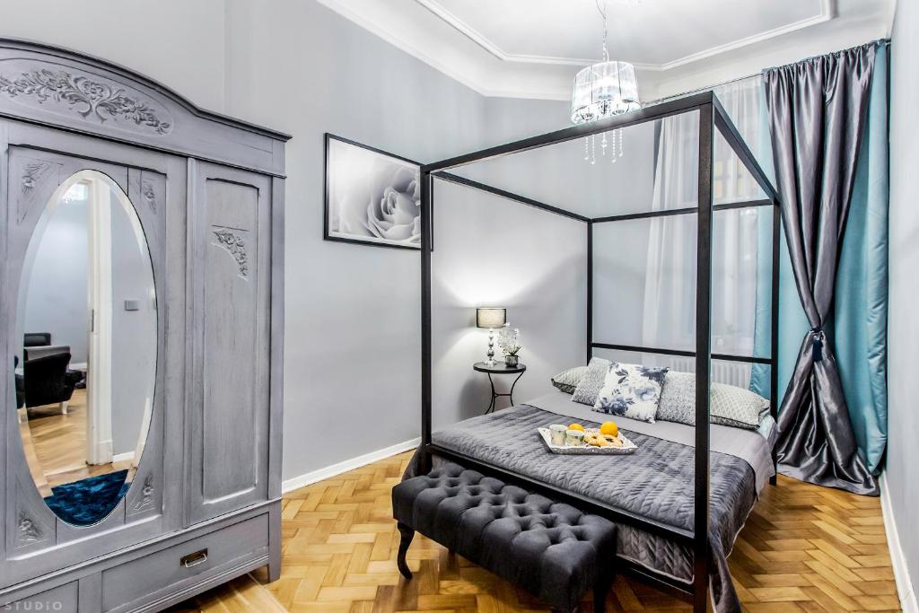 ワルシャワにあるClickTheFlat Palace Of Culture Apartmentのベッドルーム(四柱式ベッド1台、鏡付)