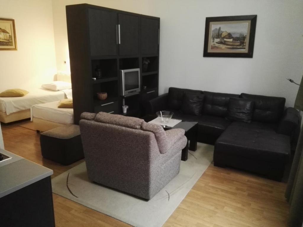 a living room with a couch and a chair and a table at Guest House Amico in Vranje