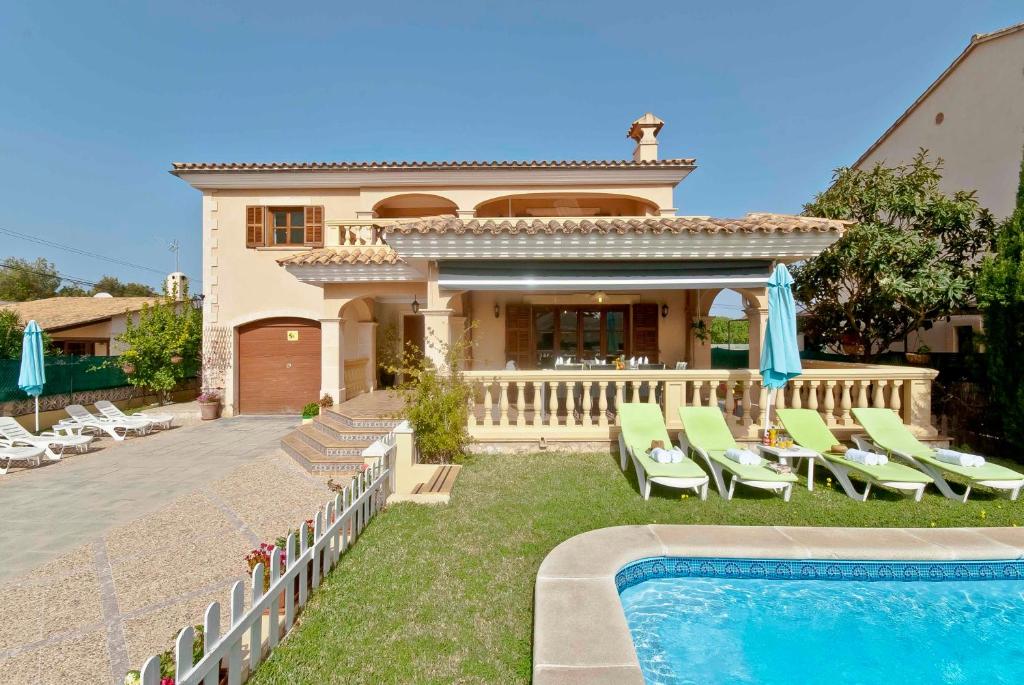 a villa with a swimming pool in front of a house at Llac Blau - Mediterranean Styled with Pool in Alcudia