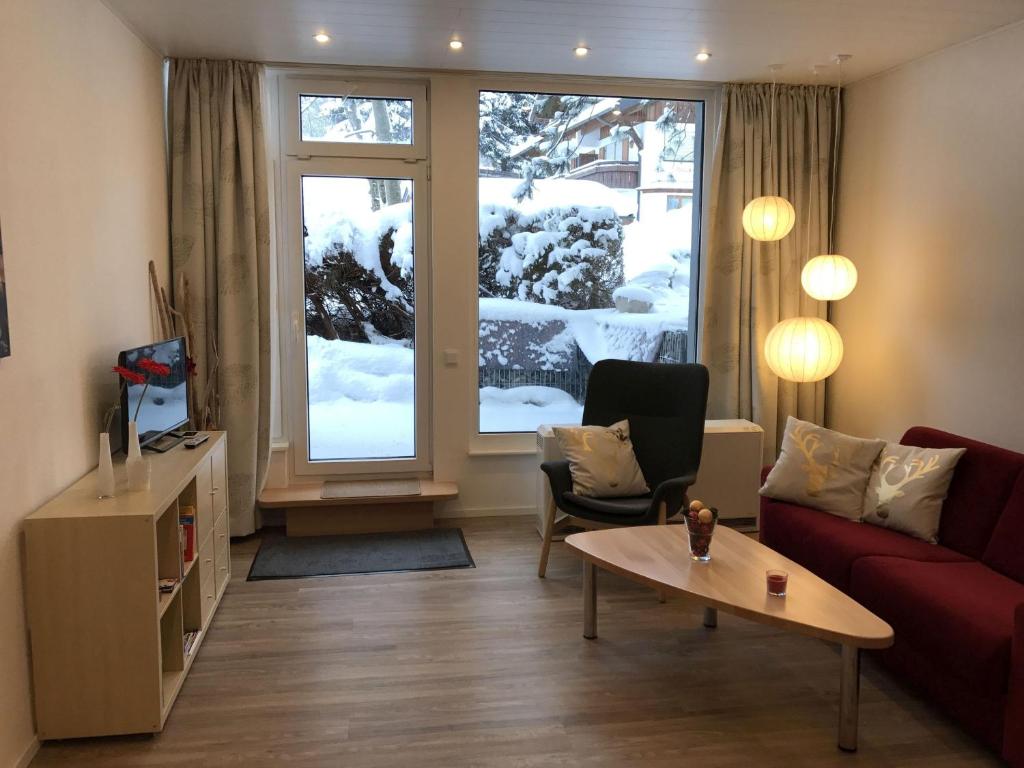 uma sala de estar com um sofá vermelho e uma janela em Sport-Alpin-Wohnung-5 em Oberstdorf