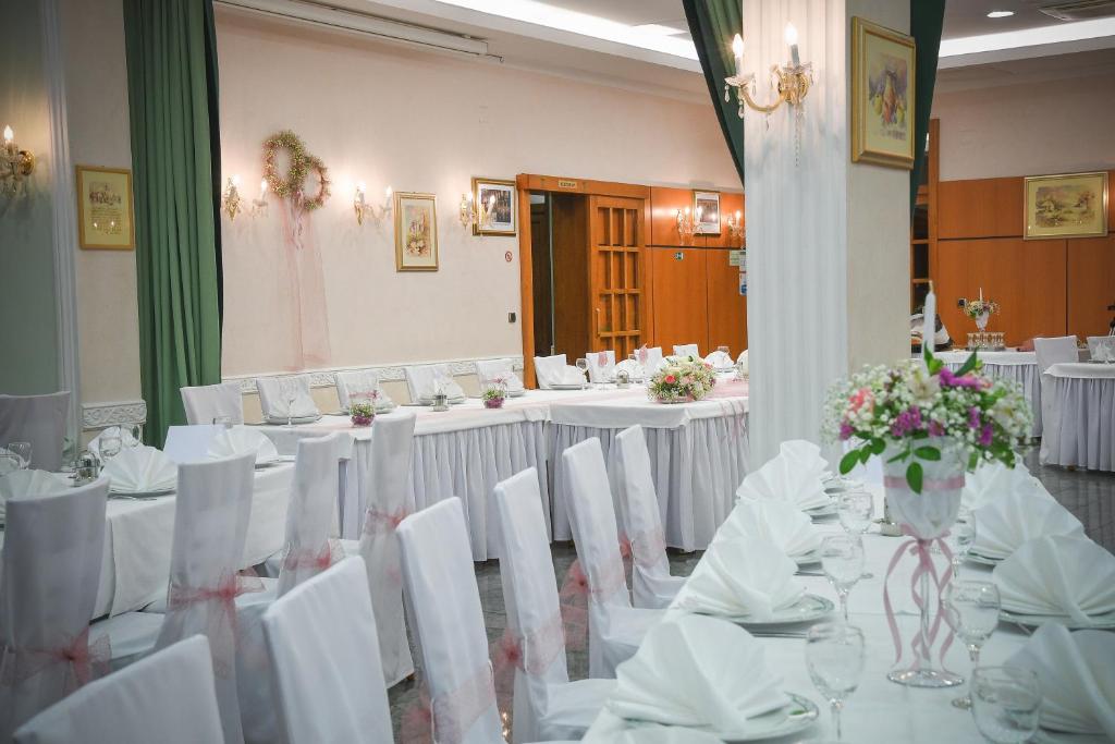 salę bankietową z białymi stołami i białymi krzesłami w obiekcie Hotel Kralj w mieście Donji Kraljevec
