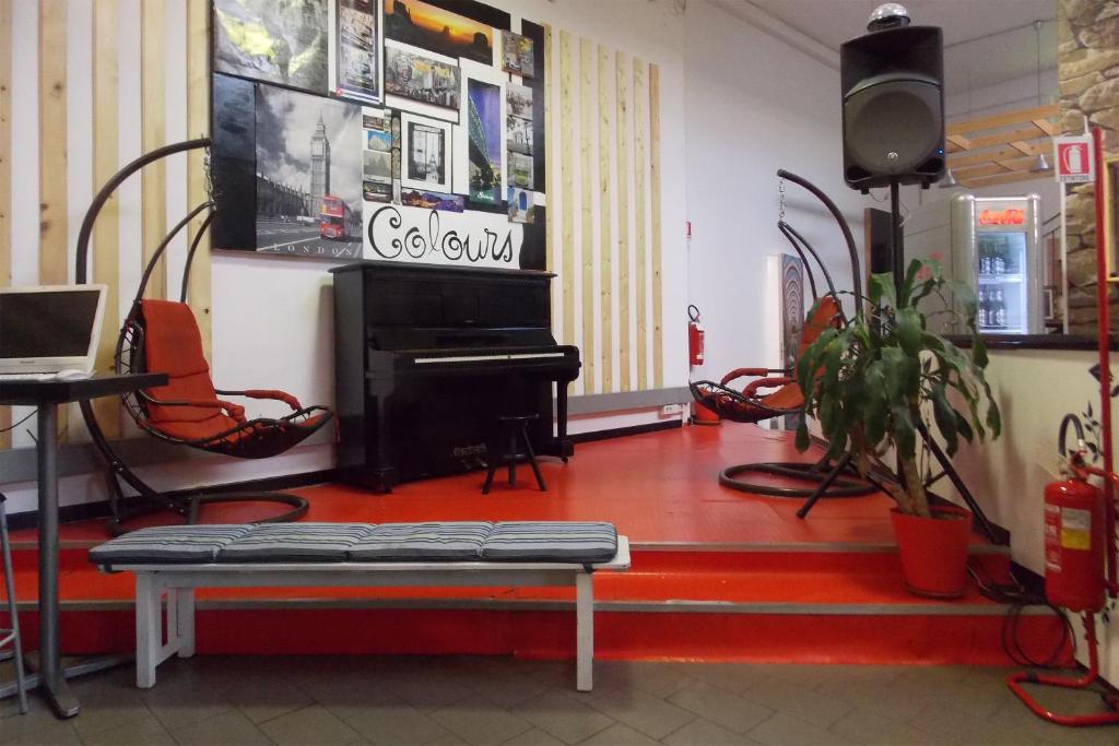 een kamer met een piano en een tafel en stoelen bij Hostel Colours in Milaan