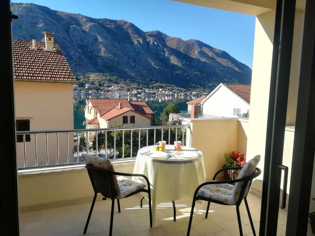 a table on a balcony with a view of a mountain at Apartments Castello in Kotor