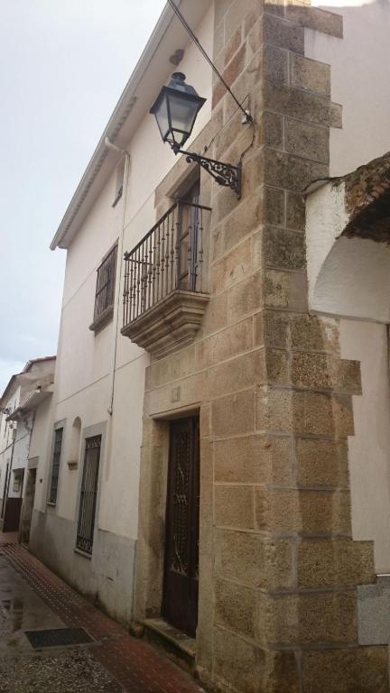 a building with a balcony and a light on it at Apartamentos Andrada in Casar de Cáceres