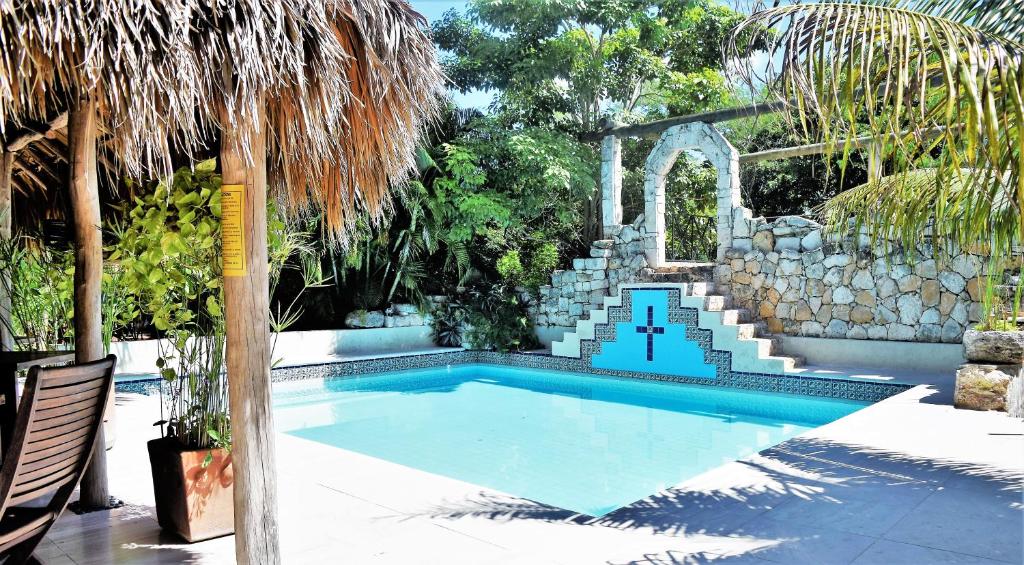 una piscina in un cortile con un muro di pietra di Hacienda Hotel Santo Domingo a Izamal