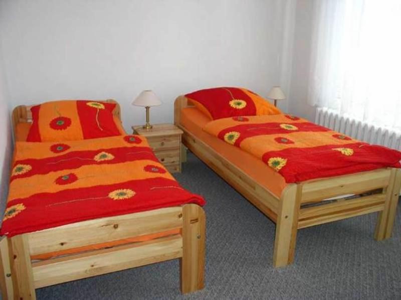 バート・ドーベランにあるFerienwohnung Bad Doberan MOST 2081の赤とオレンジのカバーが付いたベッド2台が備わる客室です。