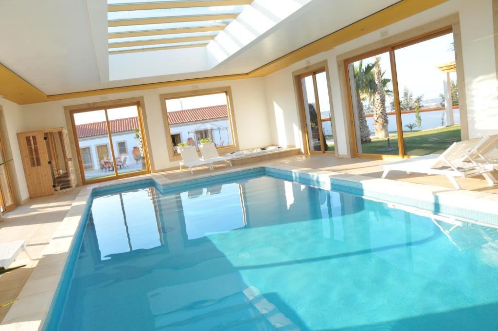 a large swimming pool with blue water in a house at Quinta Do Molinu in Lourinhã