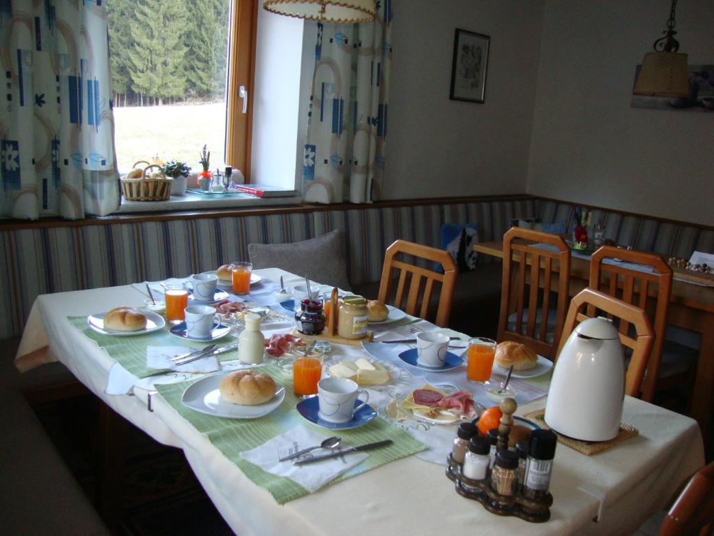 a table with breakfast food and orange juice on it at Haus Eder Burgi in Nikolsdorf