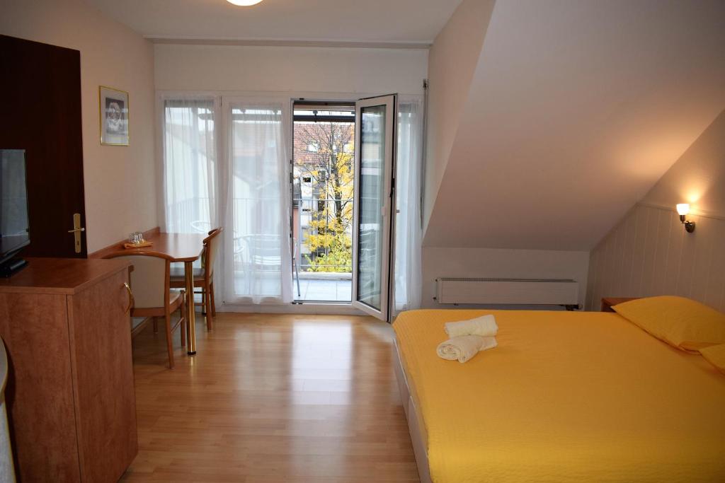 a hotel room with a yellow bed and a table at Hotel Locanda in Basel