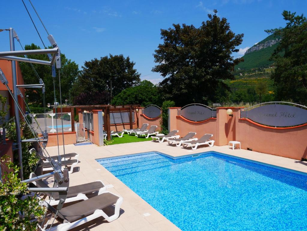 a pool with chaise lounge chairs and a swimming pool at Cévenol Hôtel in Millau