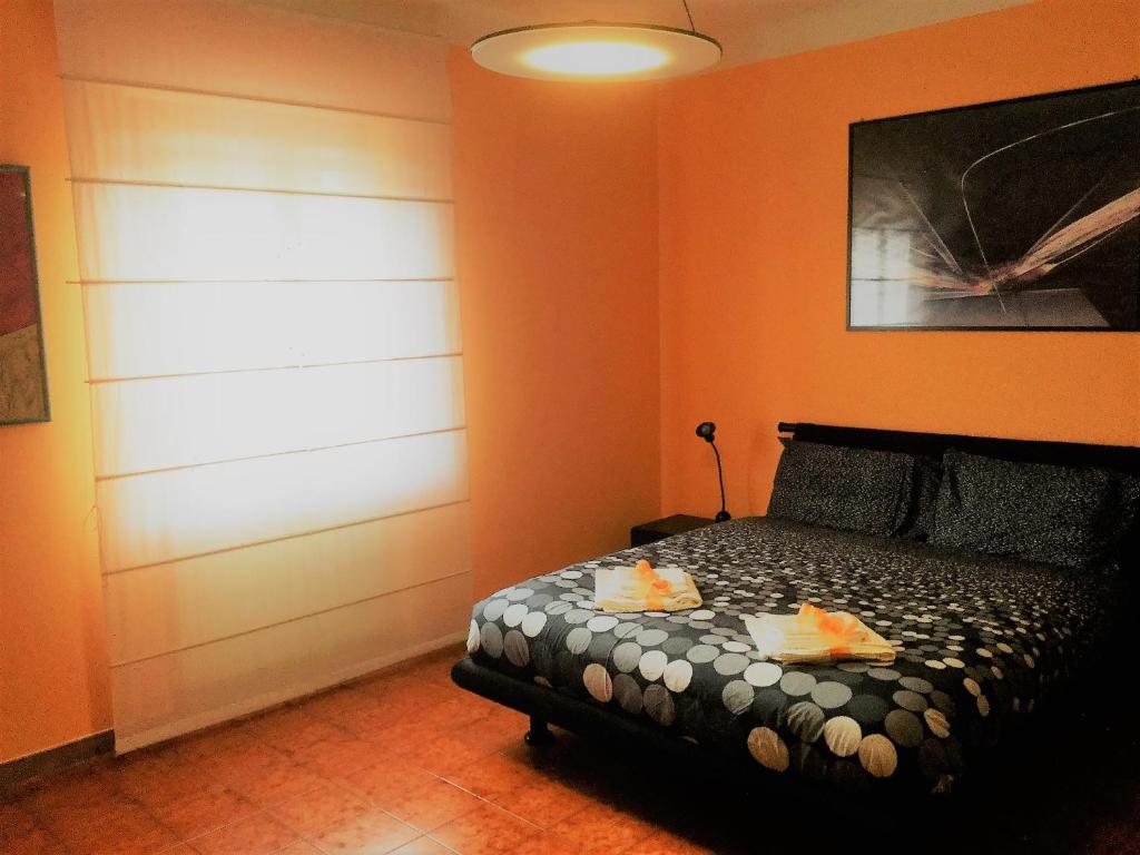 a bedroom with orange walls and a bed with fruit on it at Sabry apartment in San Giuliano Terme