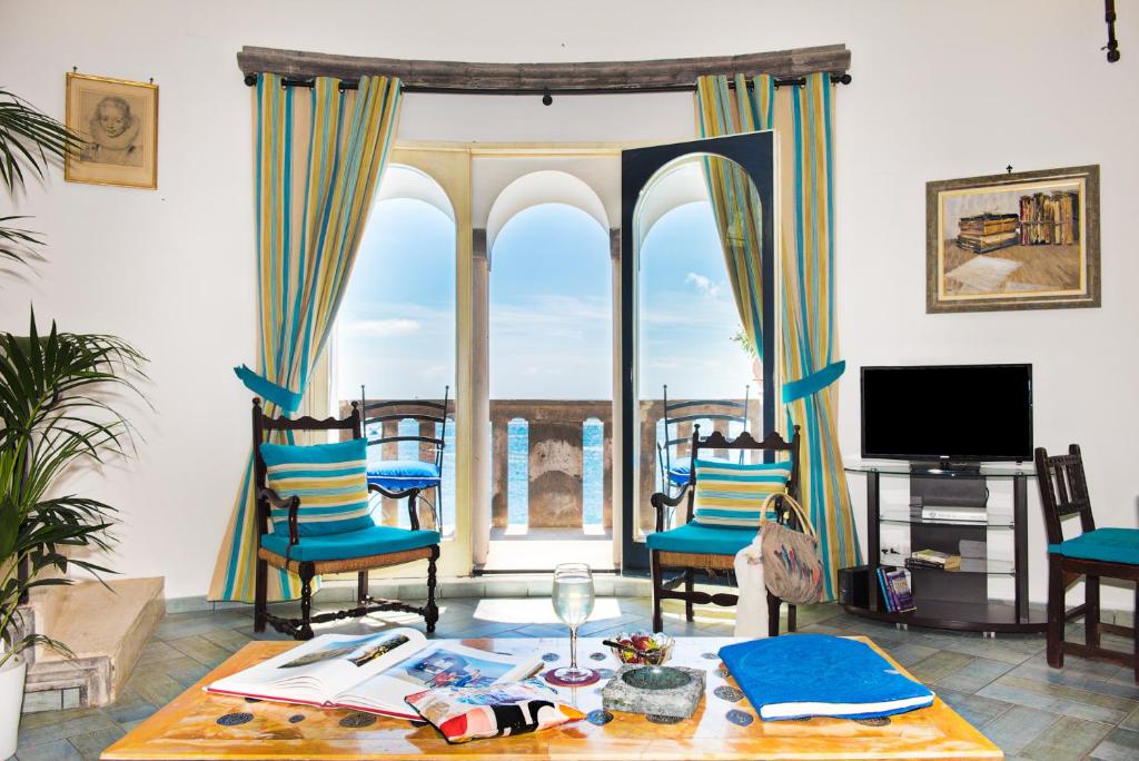 sala de estar con mesa, sillas y ventana en Villa Torre Trasita luxury suites, en Positano