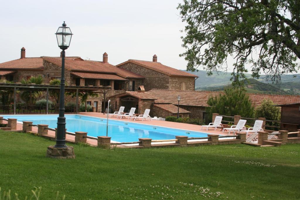 einen großen Pool mit Stühlen und einer Laterne in der Unterkunft Agriturismo Podere del Vescovo in Montenero
