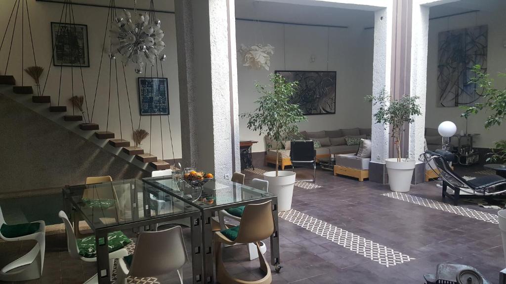 a lobby with a glass table and chairs and stairs at Dar d'Art in Marrakesh