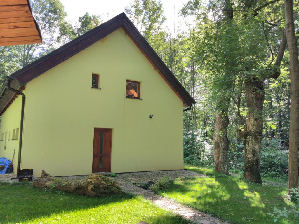a small white house in the woods at Cottage Refresh in Banská Štiavnica