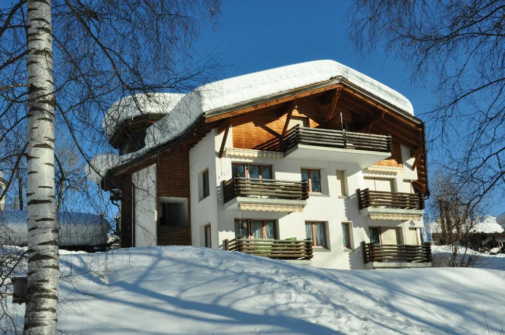uma casa com neve no telhado em Lakeside - 3.5 Zimmer Ferienwohnung am Laaxersee em Laax