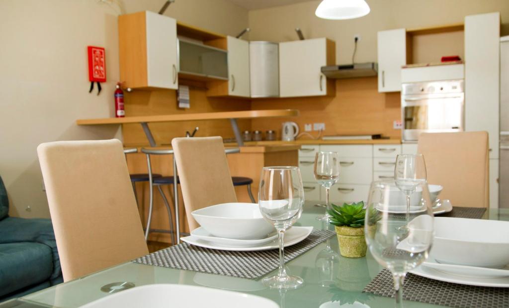 a dining room table with wine glasses on it at No 6 Poseidon Apartment in St. Julianʼs