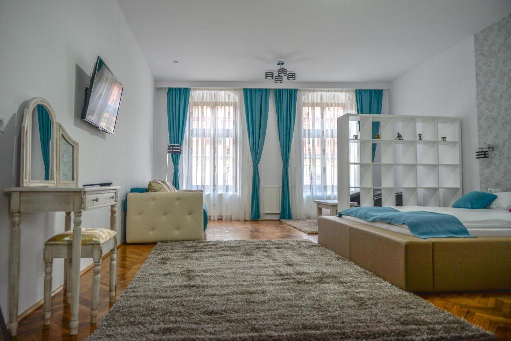 - une chambre avec un lit, une commode et un bureau dans l'établissement Central Apartments, à Sibiu