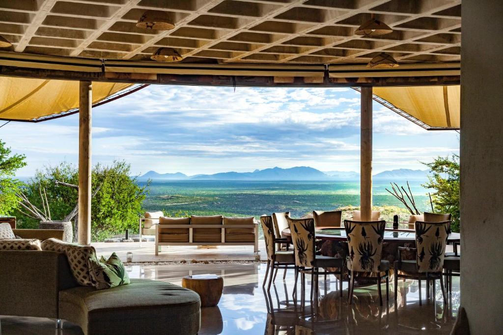 ein Esszimmer mit einem Tisch und Stühlen mit Aussicht in der Unterkunft Omurenga in Omaruru