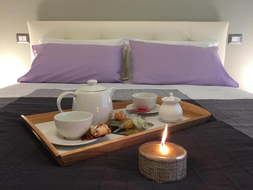 a tray with tea sets and a candle on a bed at Sweet Home Roma in Rome