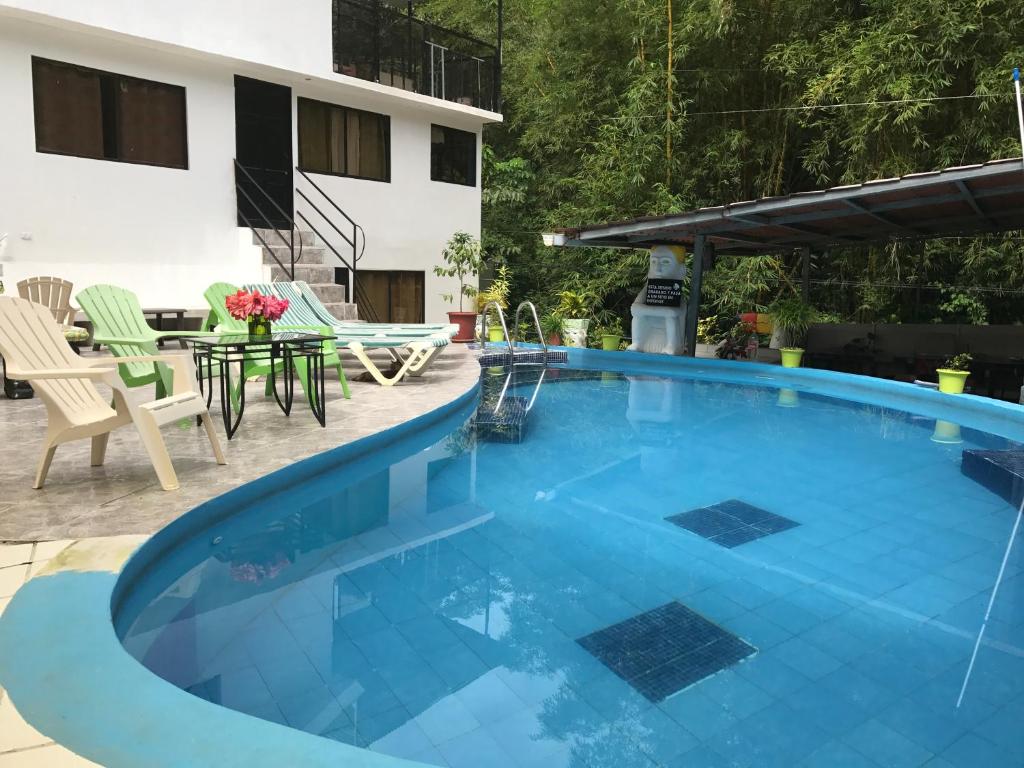 a large blue swimming pool with a table and chairs at Hotel Cafe Del Mar, En Valle Pura Vida in Manuel Antonio