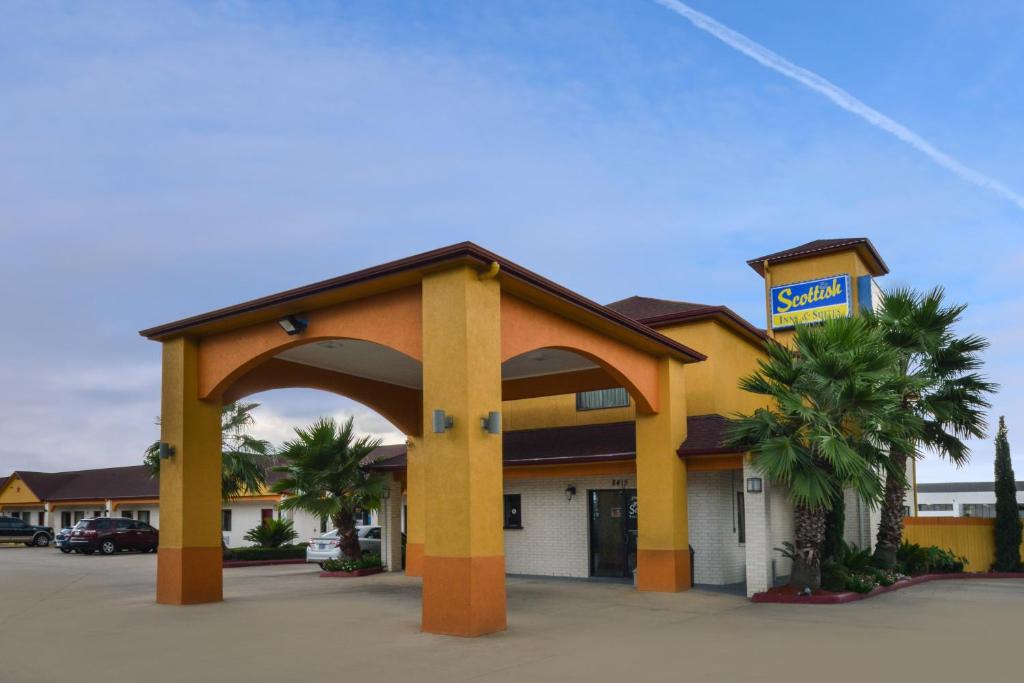 a hotel building with a sign in front of it at Scottish Inn and Suites Highway Six South in Mission Bend