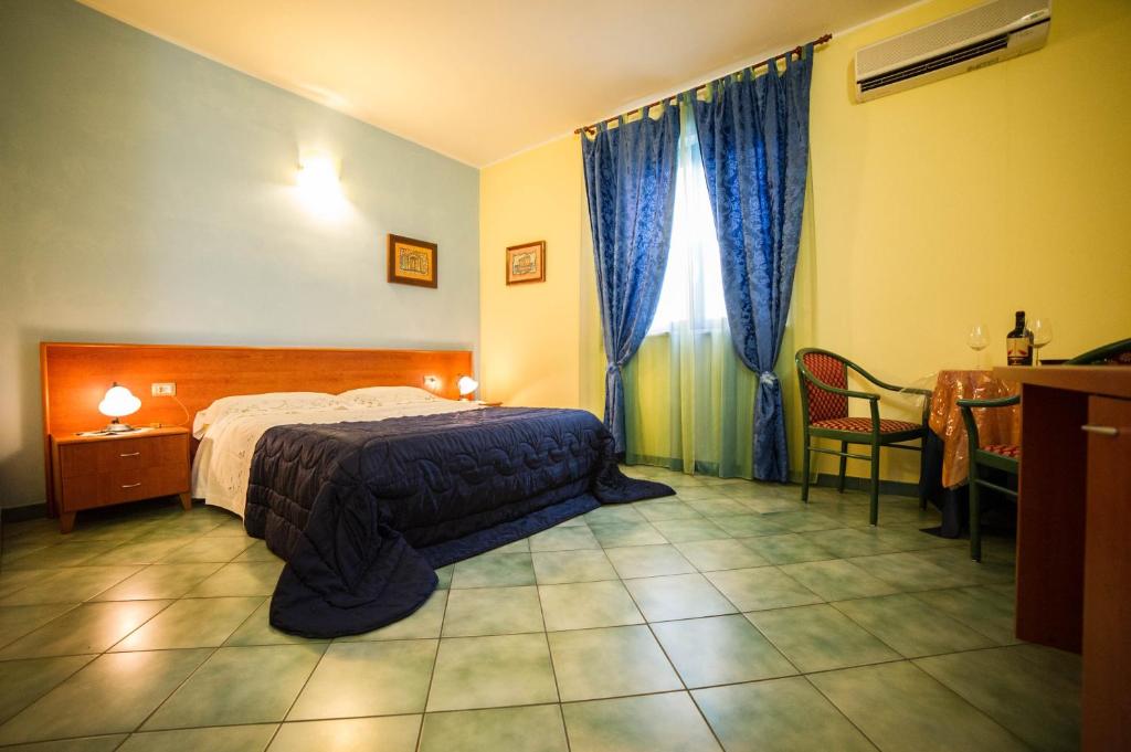 a bedroom with a bed and a table and chairs at La Lanterna in Martano