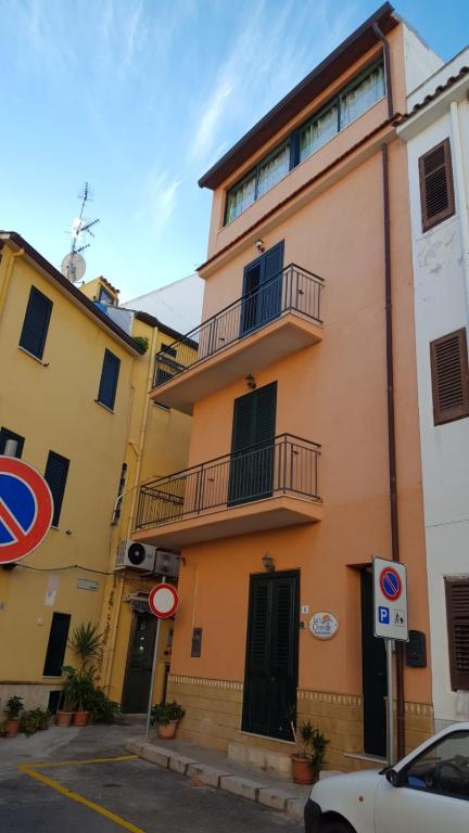 a yellow building with a balcony on a street at Le Tre Caravelle in Trabia