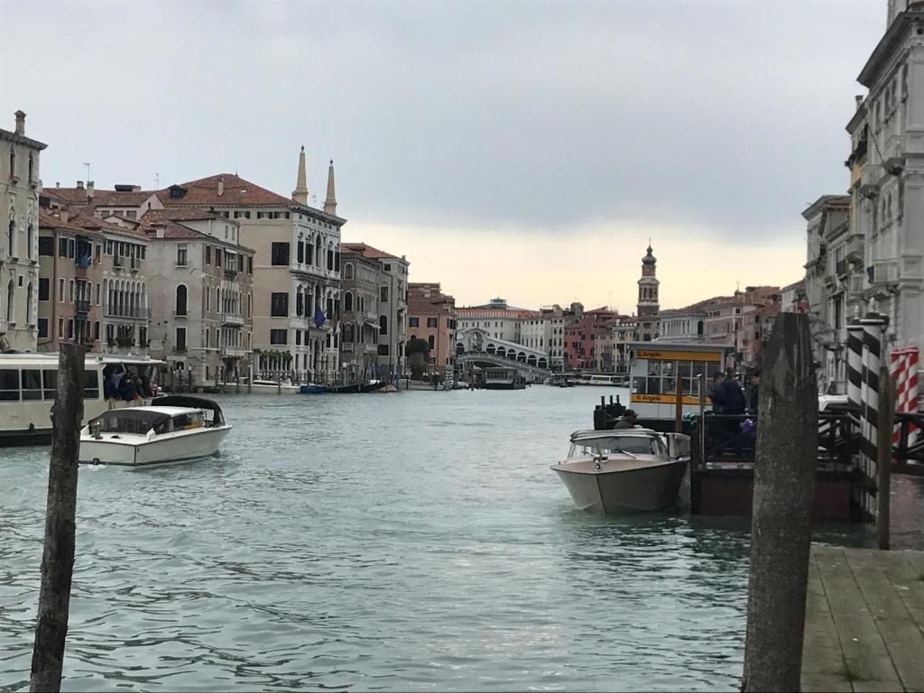 dwie łodzie zacumowane na kanale w mieście w obiekcie Palazzo Grassi and Accademia Bridge superb House w Wenecji